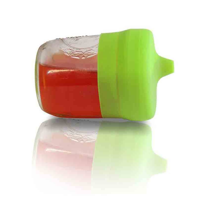 Couvercle universel en silicone vert posé sur un verre contenant du liquide, pour éviter les renversements