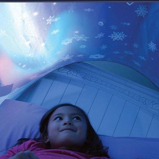 Enfant allongé sous le paravent de lit au décor polaire, isolé des stimulations visuelles de la chambre