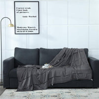 couverture lestée gris foncé sur un canapé